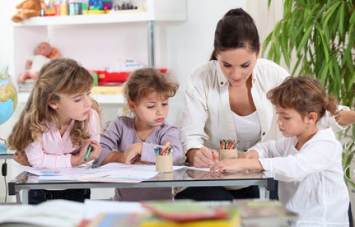 Woman helping a group of girls with their homework